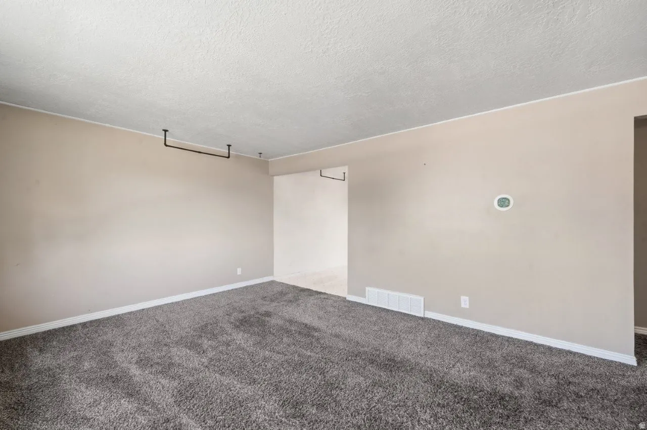 Generous living space with carpet, neutral tones, and an open flow into the dining room. Clean, blank slate ready for your vision.