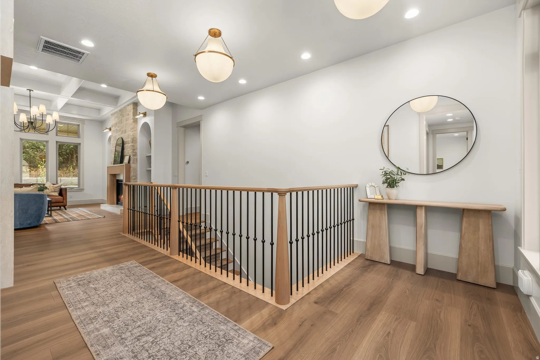 Wood-finish flooring throughout, with a hardwood staircase featuring black metal balusters and a wood handrail