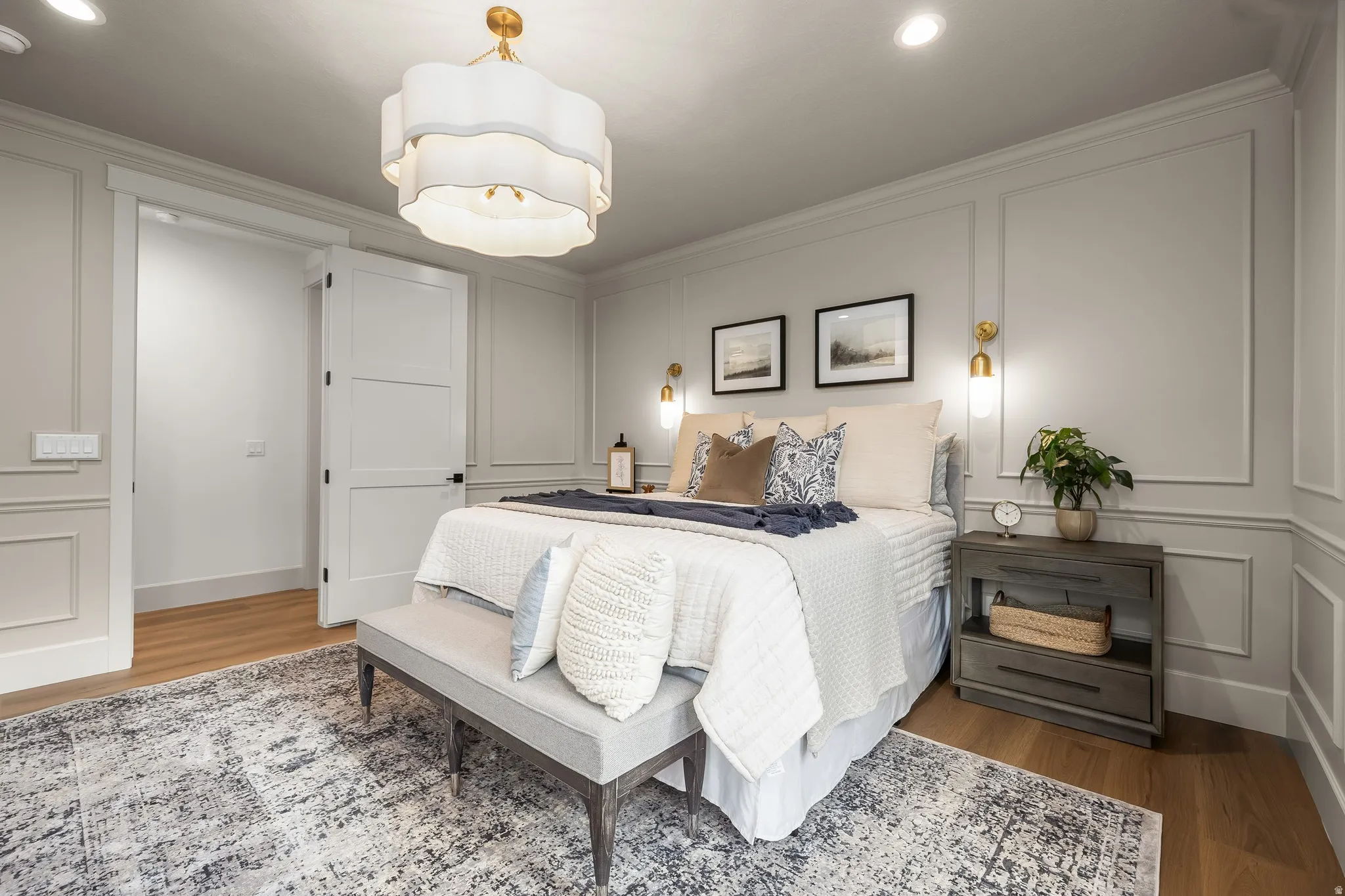 Hardwood-finish flooring, accent wall paneling, recessed lighting, and a decorative ceiling fixture