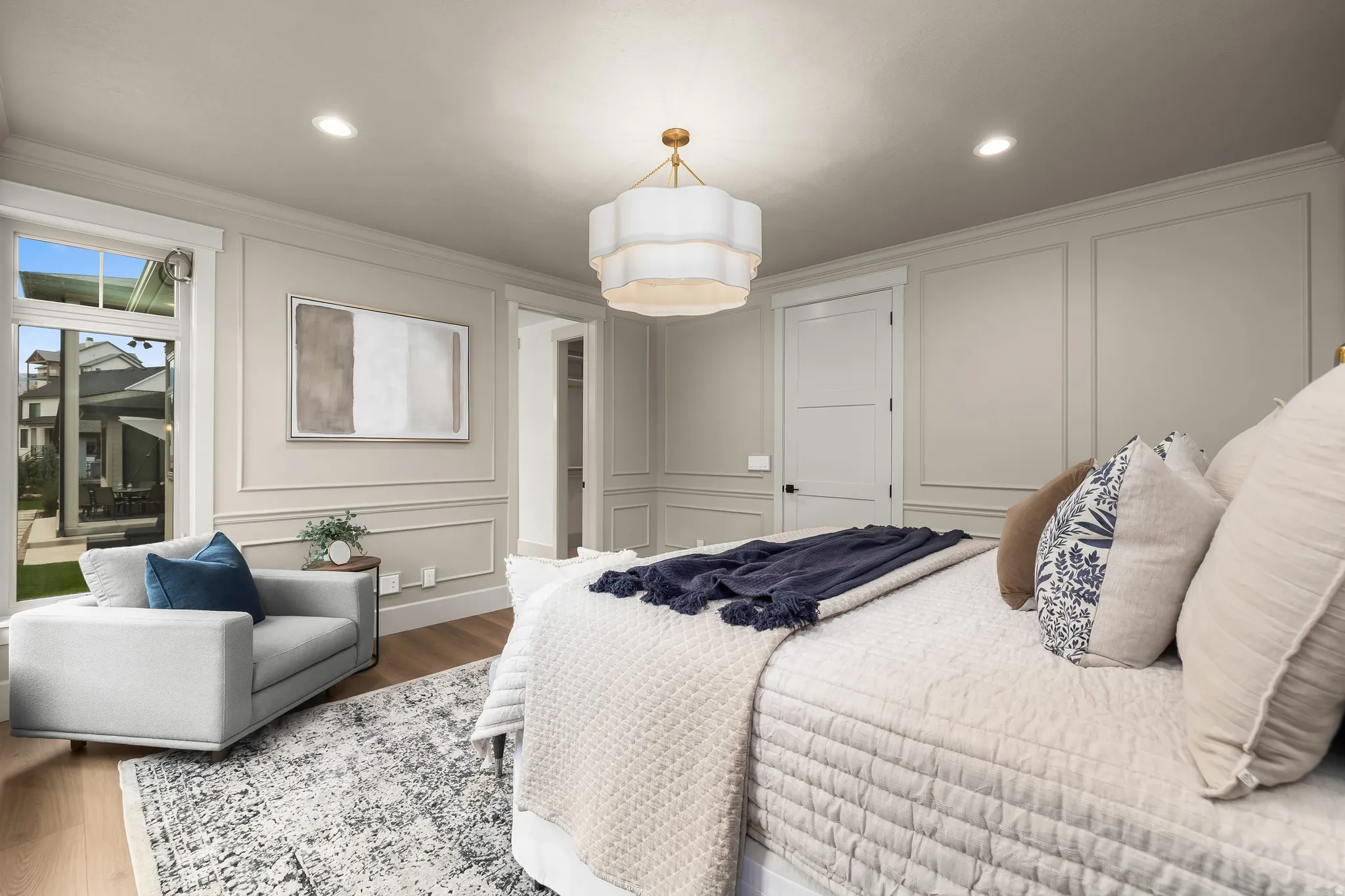 Recessed lighting, wood-finish flooring, and panel molding create a sophisticated atmosphere
