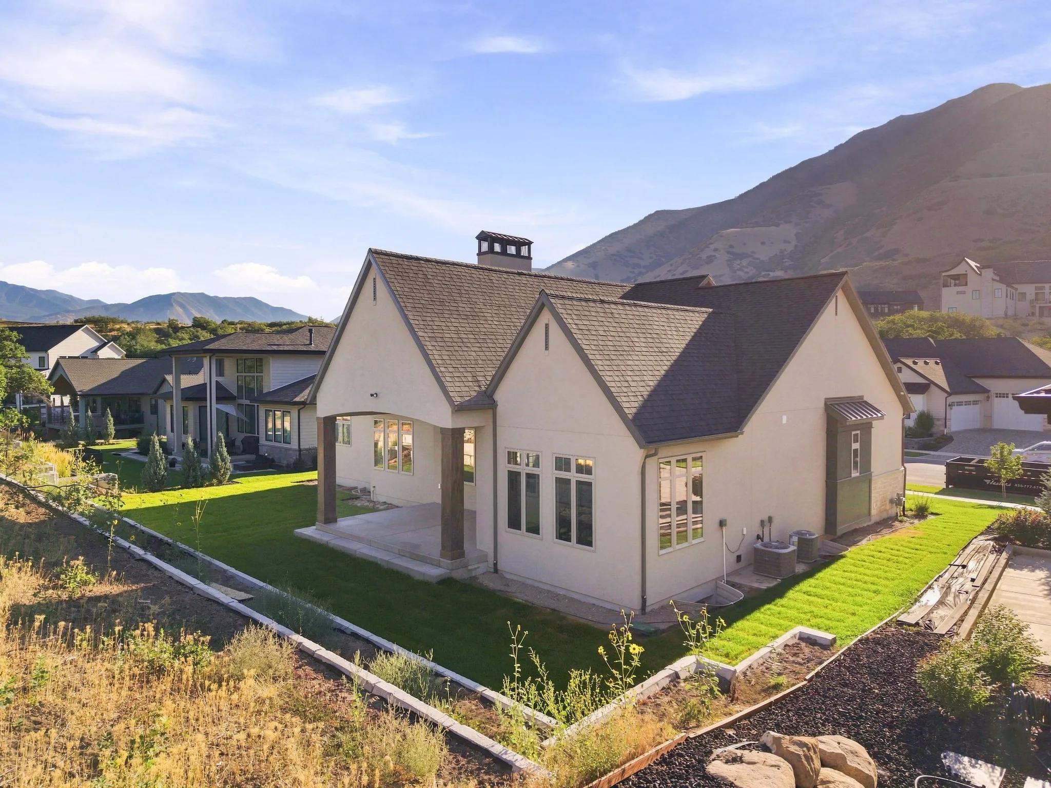 Contemporary stucco exterior with a gabled roofline and covered patio