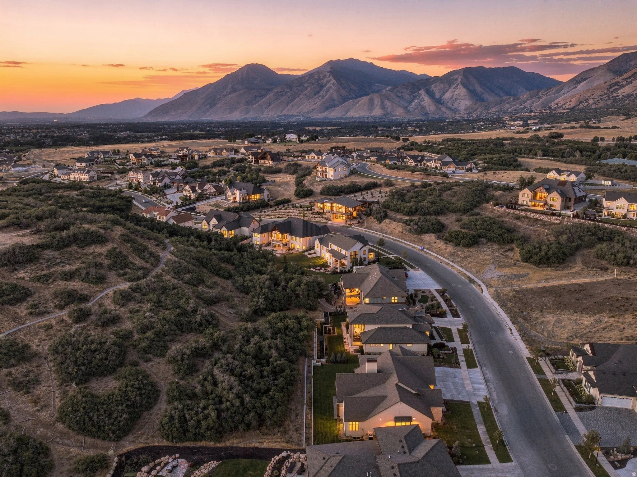 Mountain backdrop, residential area, paved roads, and scattered natural landscaping