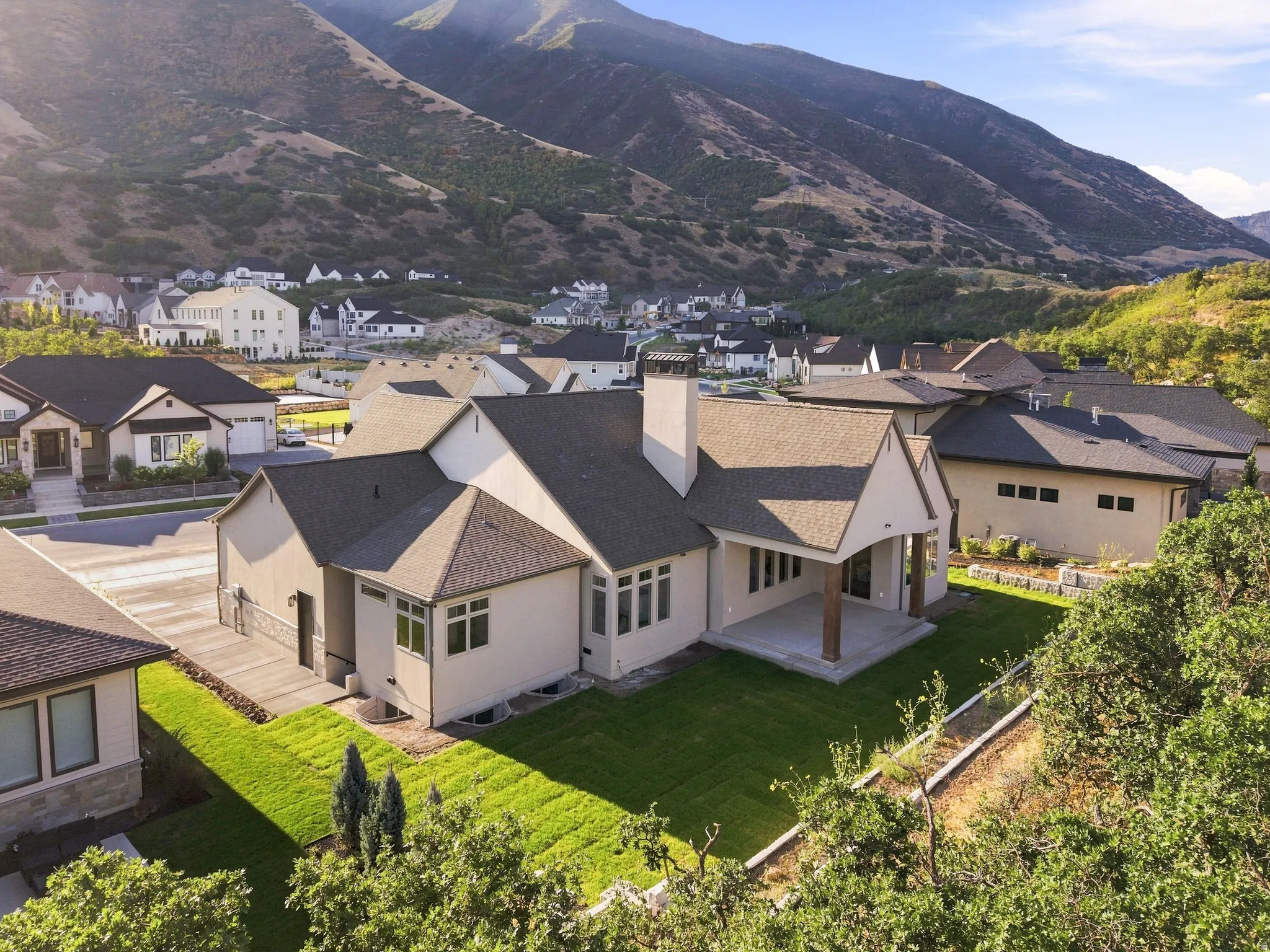 Contemporary architectural style with a covered patio, multiple windows, and a paved driveway
