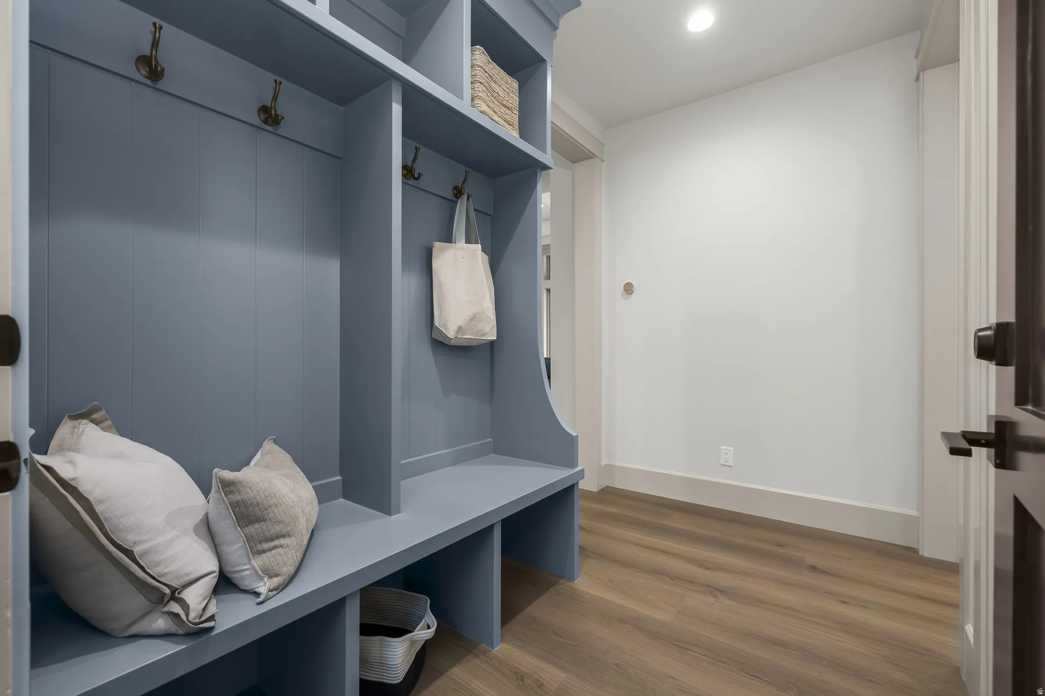 Built-in mudroom bench with storage, upper shelving, and wall hooks