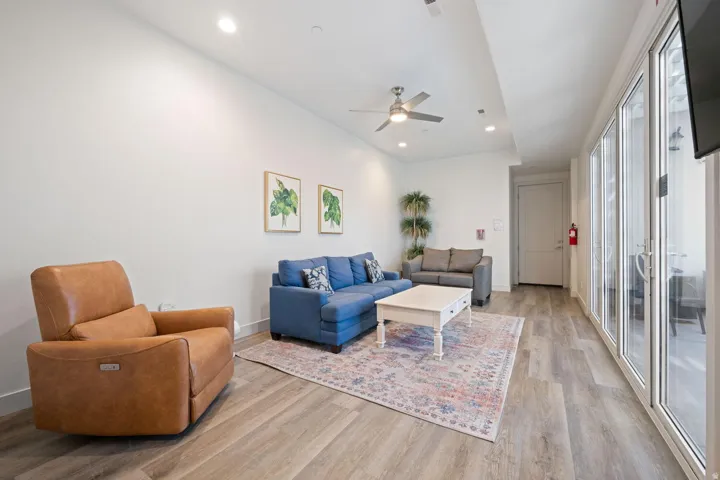 Spacious living area featuring light wood-finish flooring, recessed lighting, and a ceiling fan