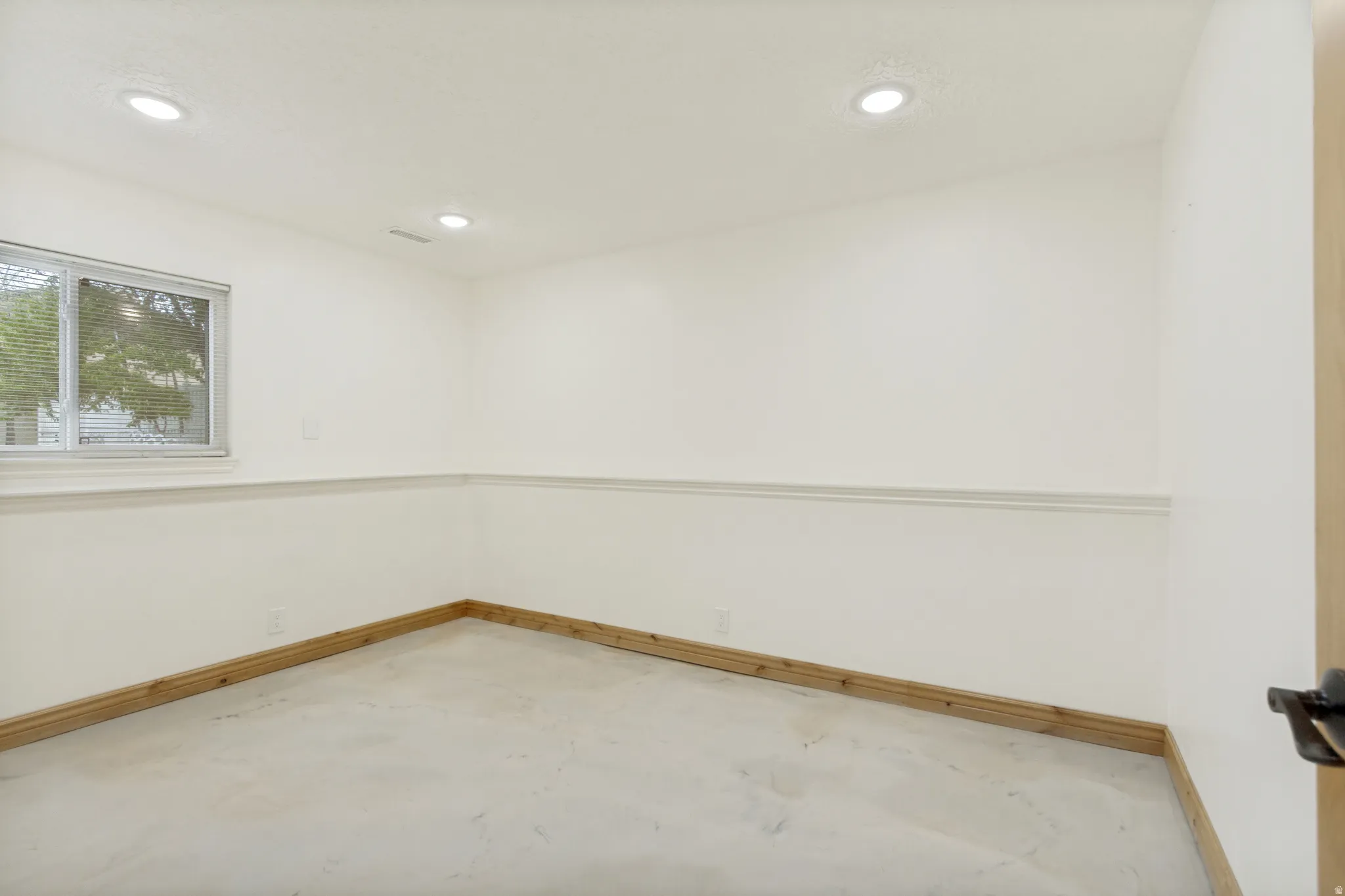 Neutral wall paint, recessed ceiling lighting, a single window, white trim, and light-toned baseboard molding