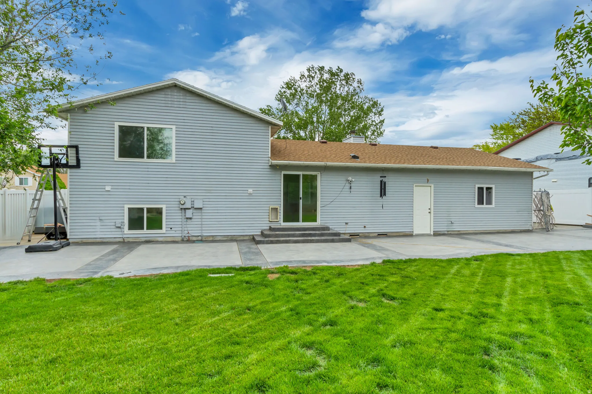 Spacious green lawn bordering a concrete patio with an integrated walkway