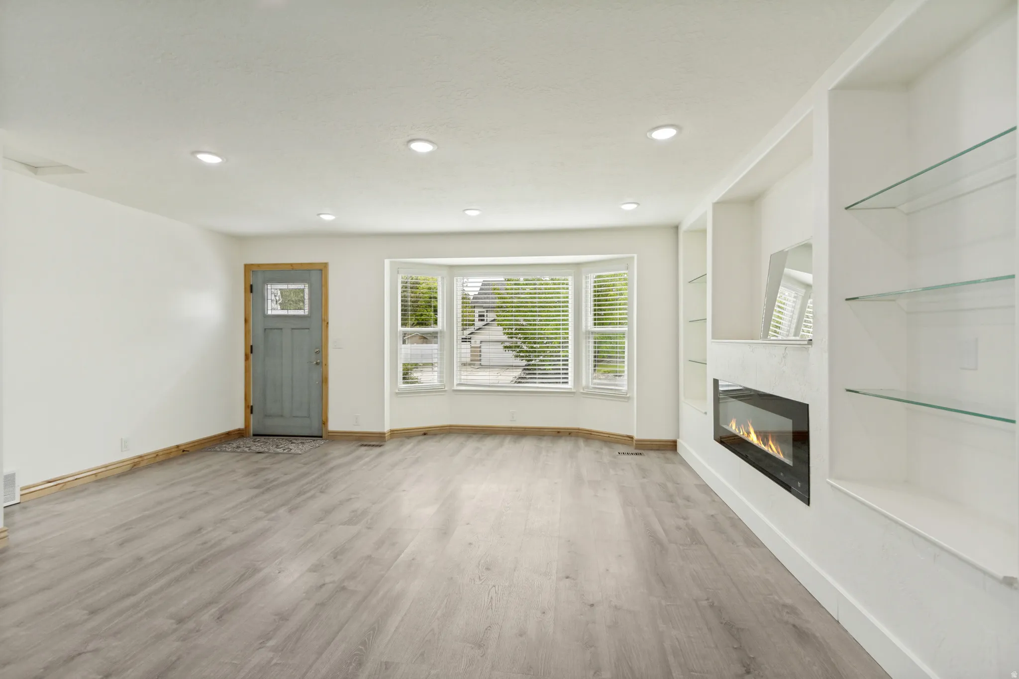Living area featuring wood-finish flooring, recessed lighting, and a bay window