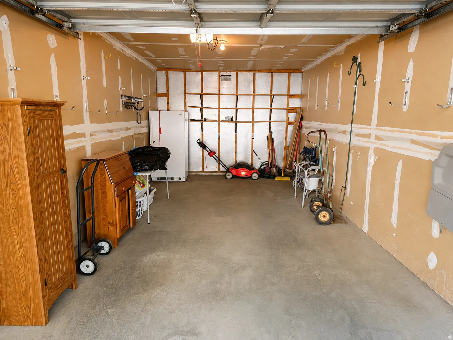 Spacious garage featuring concrete flooring and exposed wall studs