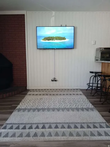 Wood-finish flooring complemented by white vertical paneling