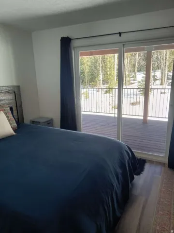 Bedroom featuring wood-finish flooring and a distressed wood-paneled headboard