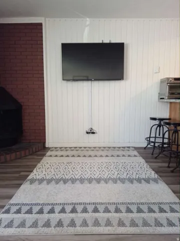 White vertical paneling walls accenting a brick fireplace with a dark firebox