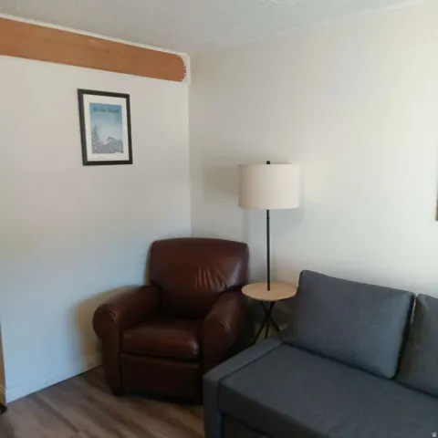 Corner room featuring wood-finish flooring, white walls, and a textured ceiling