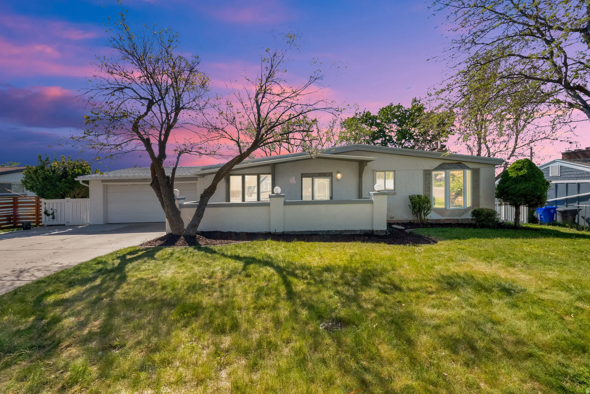 One-story residence featuring a contemporary stucco exterior, an attached two-car garage, and a concrete driveway