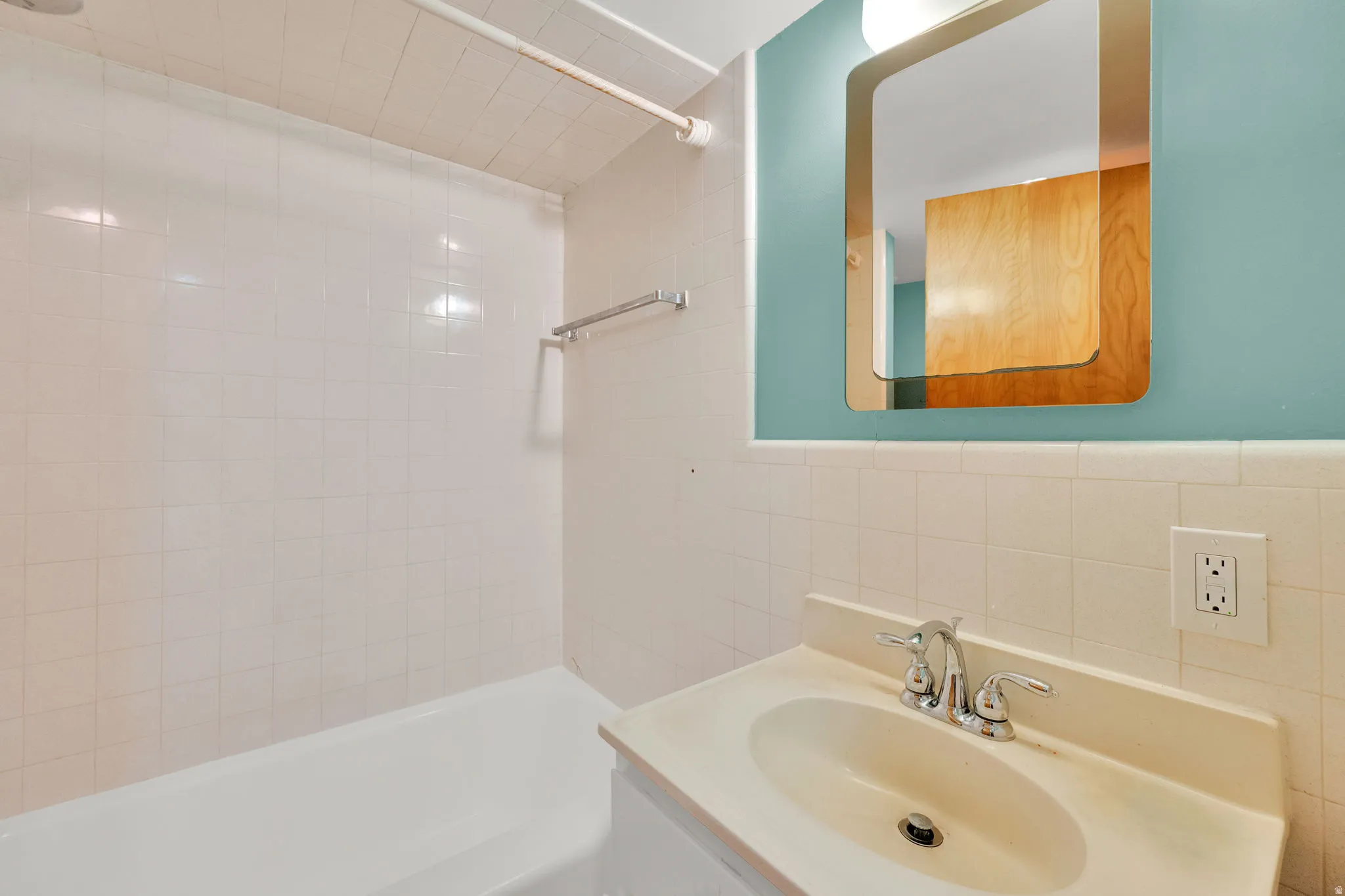 Bathroom vanity featuring a built-in sink, chrome faucet, and integrated backsplash