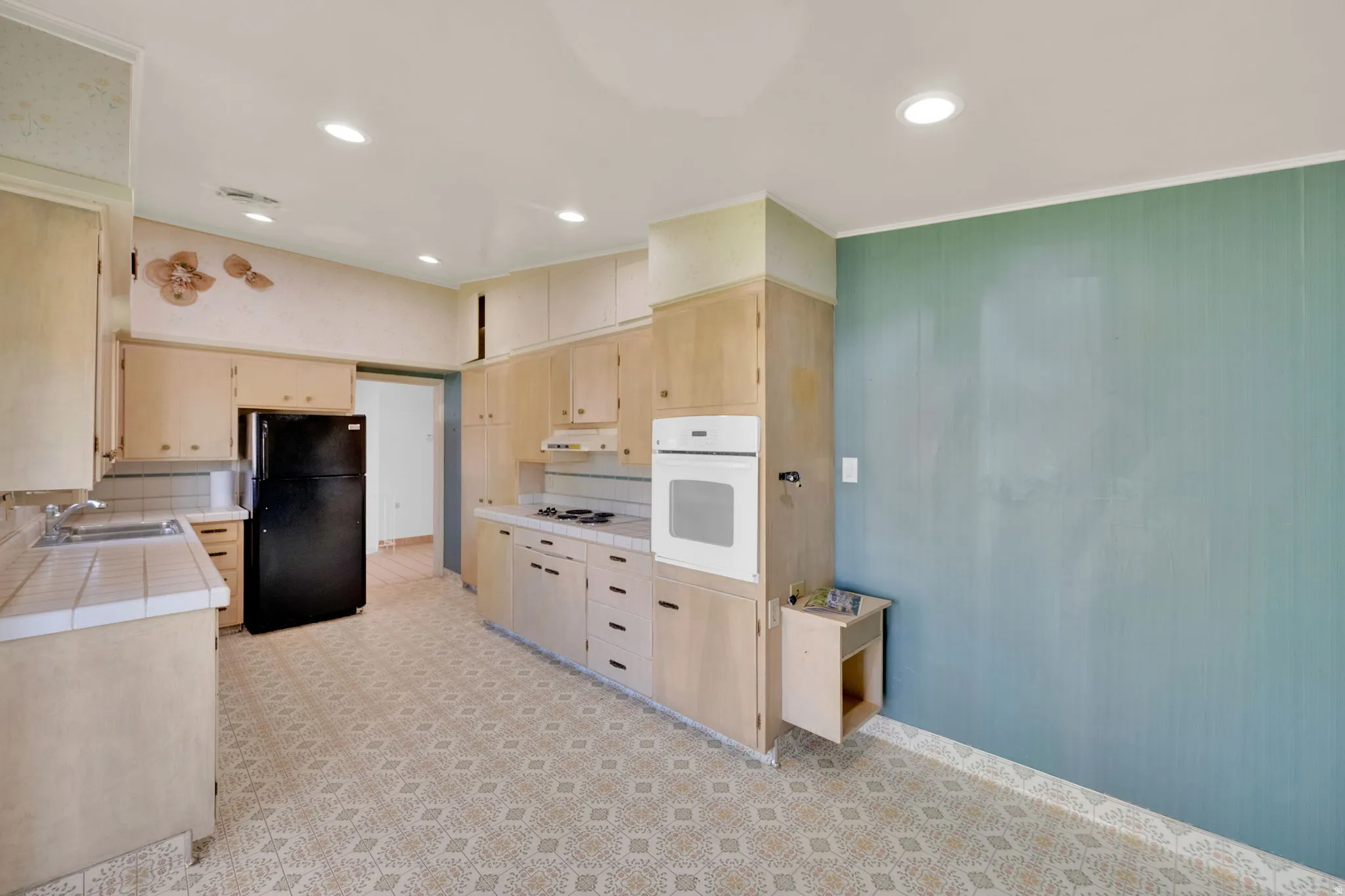 Kitchen featuring extensive light wood cabinetry, white tile countertops, a built-in oven, and a recessed lighting system