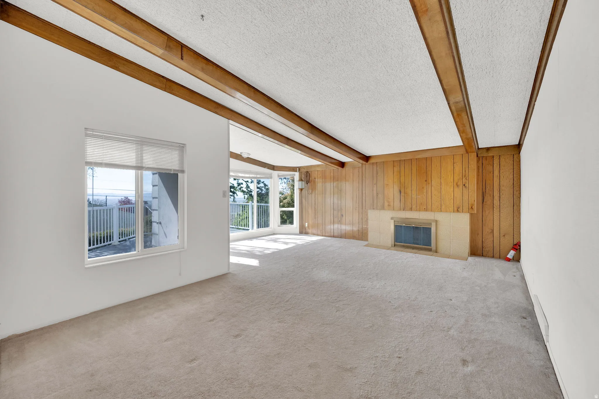 Spacious interior featuring a fireplace with a light-colored hearth and wood paneling