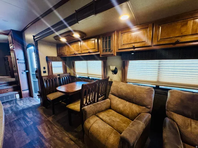 Interior living area featuring wood-finish flooring, overhead cabinetry, recessed lighting, and window blinds