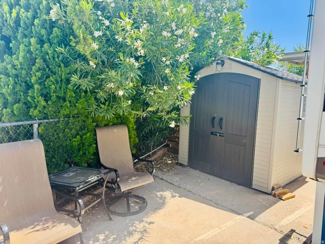 Exterior storage shed featuring a gabled roofline and double doors