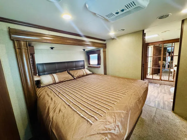 Bedroom featuring a built-in upholstered headboard, recessed lighting, wood-finish trim, and an overhead air conditioning unit