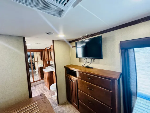 Built-in wood-finish dresser with integrated cabinetry and a wall-mounted television