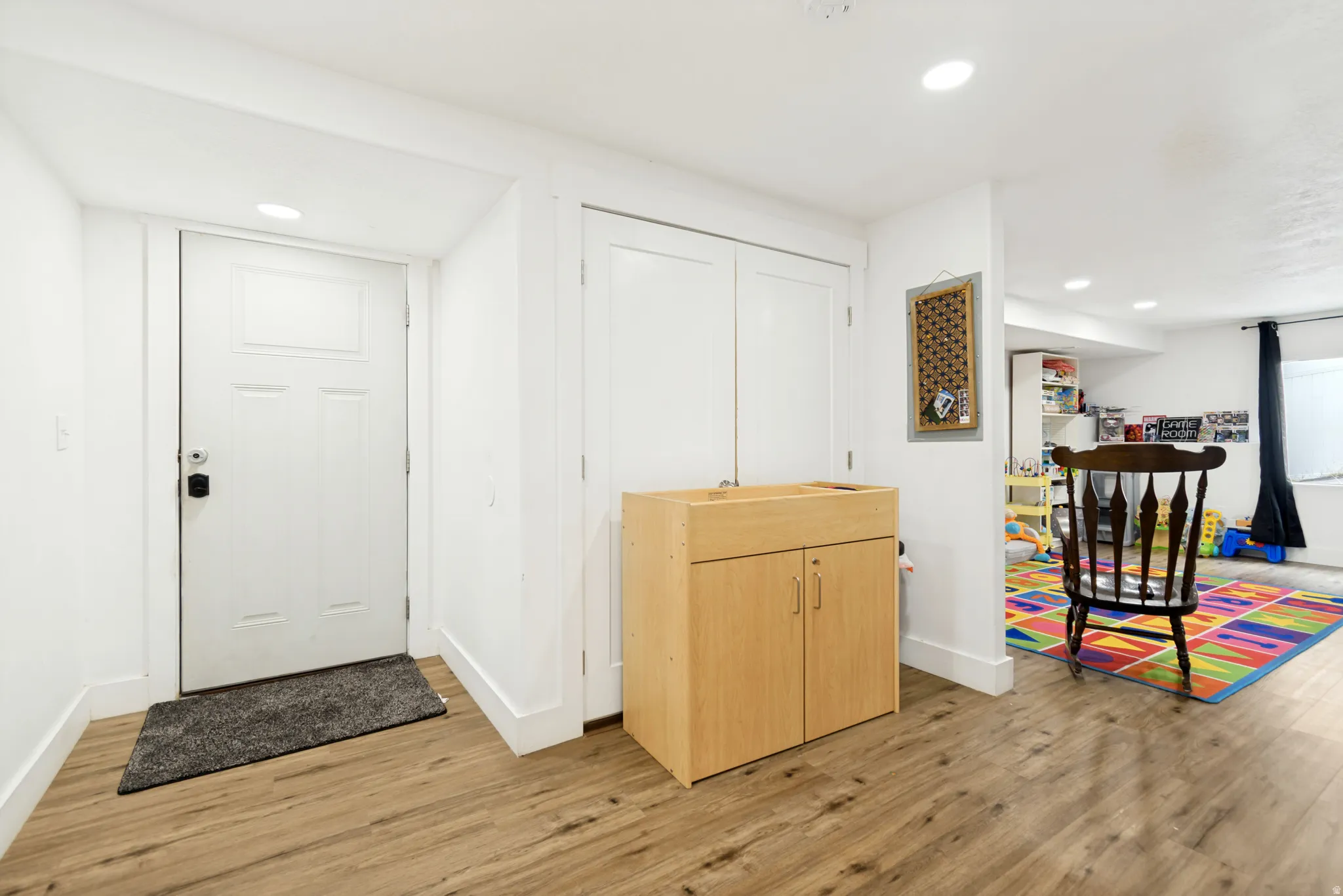 Entryway featuring wood-finish flooring, recessed lighting, and a paneled door with smart lock
