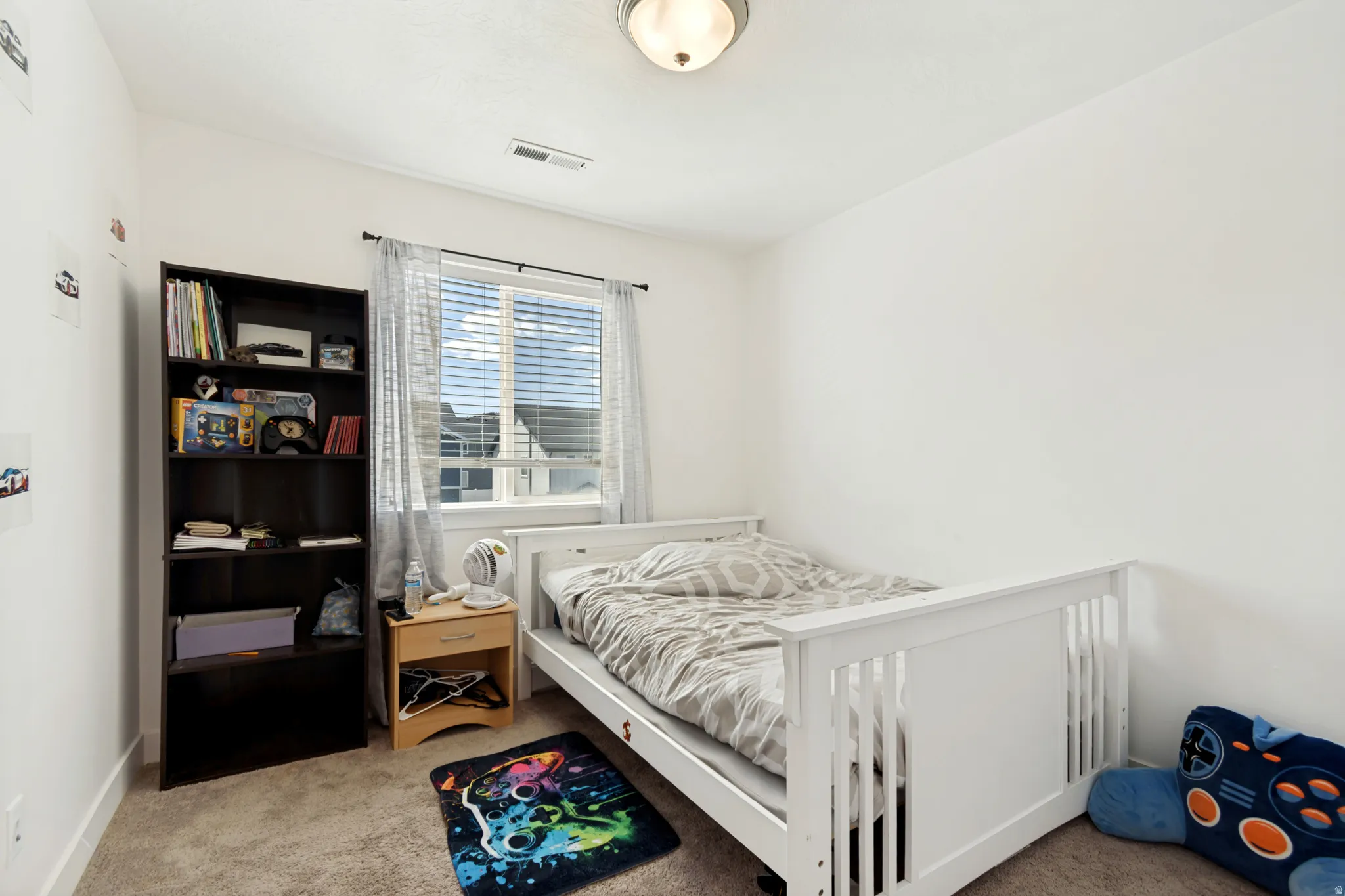 Bedroom featuring soft carpet flooring and a window with horizontal blinds