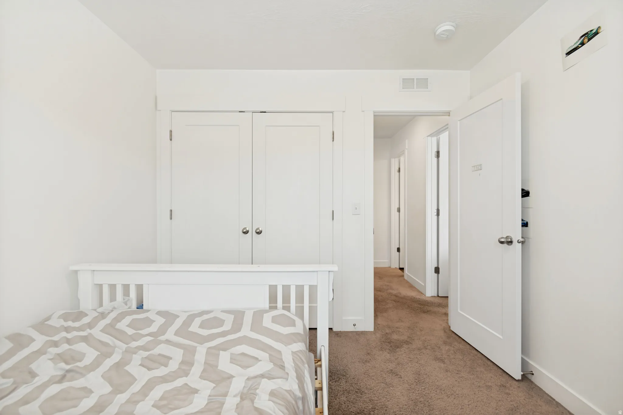 Bright room featuring neutral carpet flooring and white walls