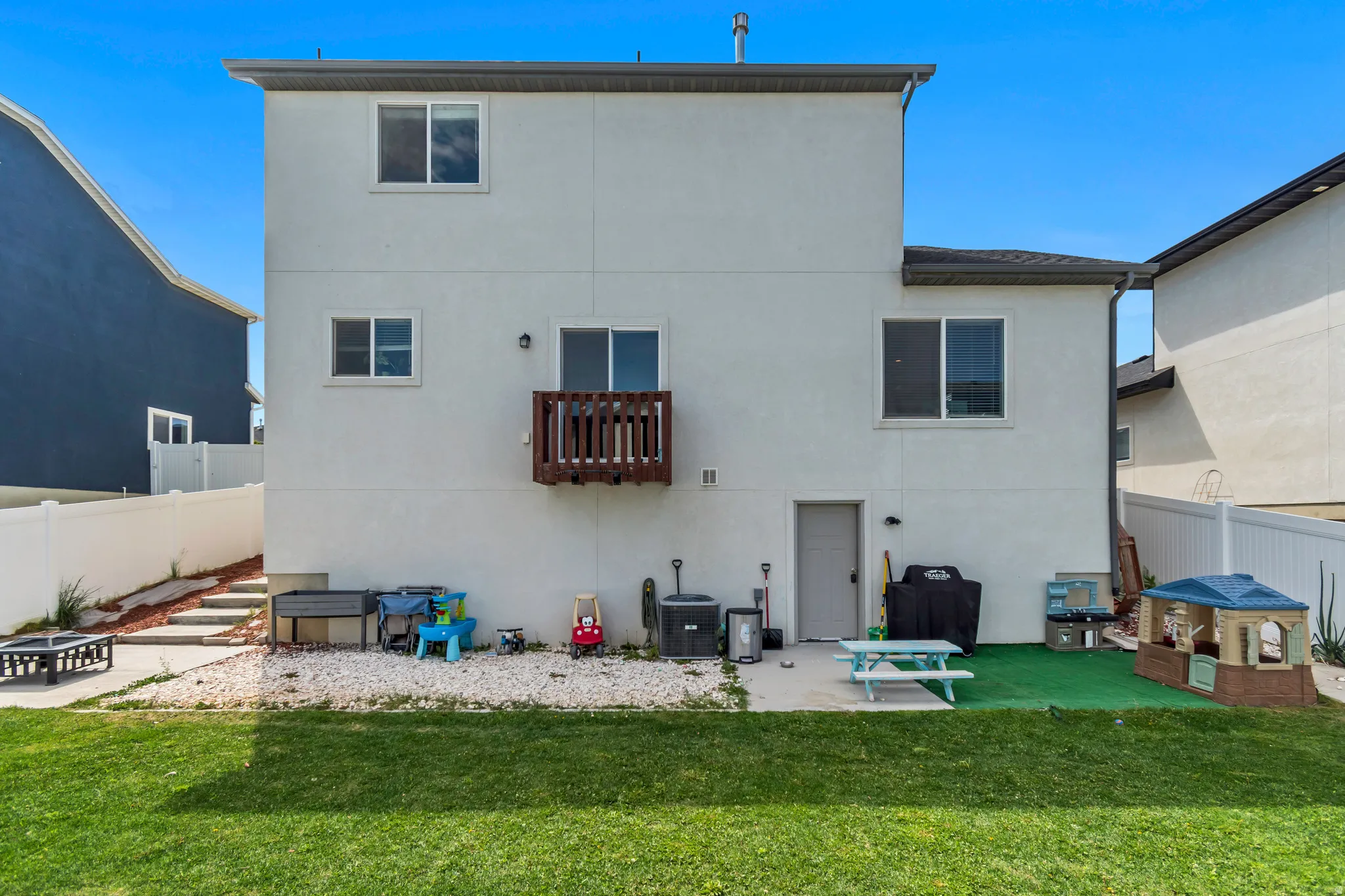 Expansive backyard featuring a manicured lawn, a concrete patio, and a dedicated gravel area