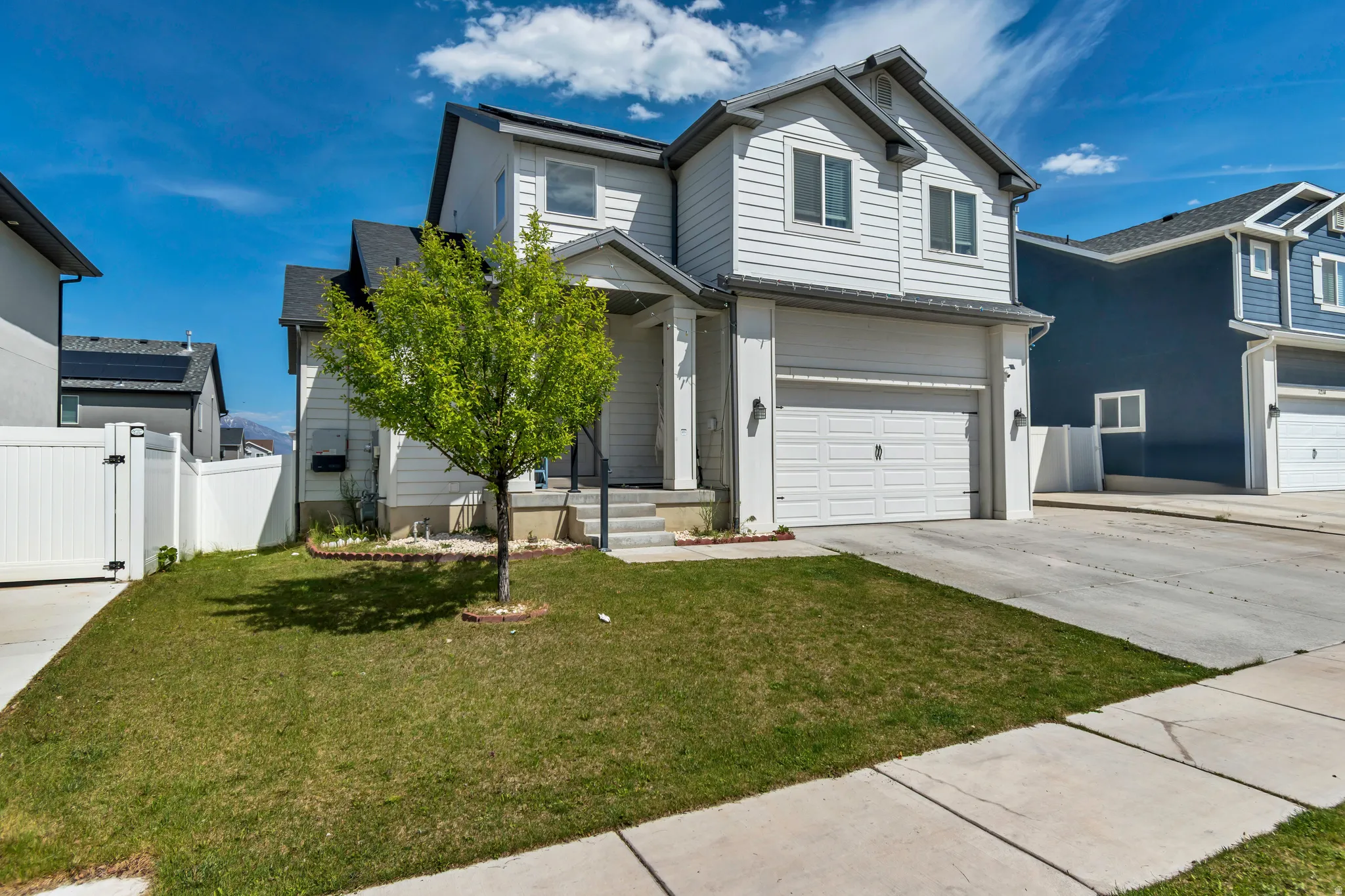 Two-story residential property with light grey siding and dark grey trim