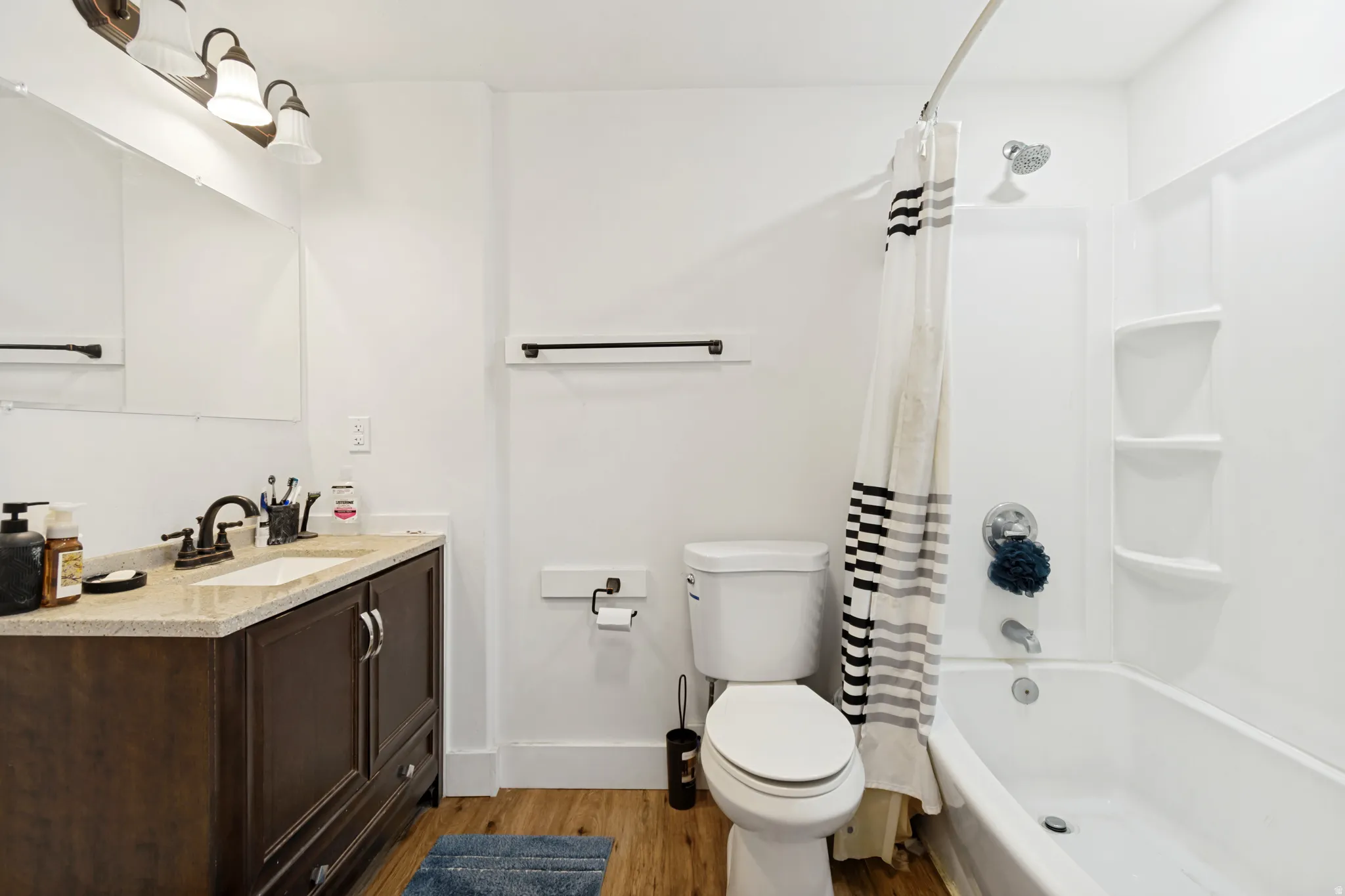 Bathroom featuring a dark wood-finish vanity with a light-toned countertop, a rectangular undermount sink, and bronze-finish fixtures