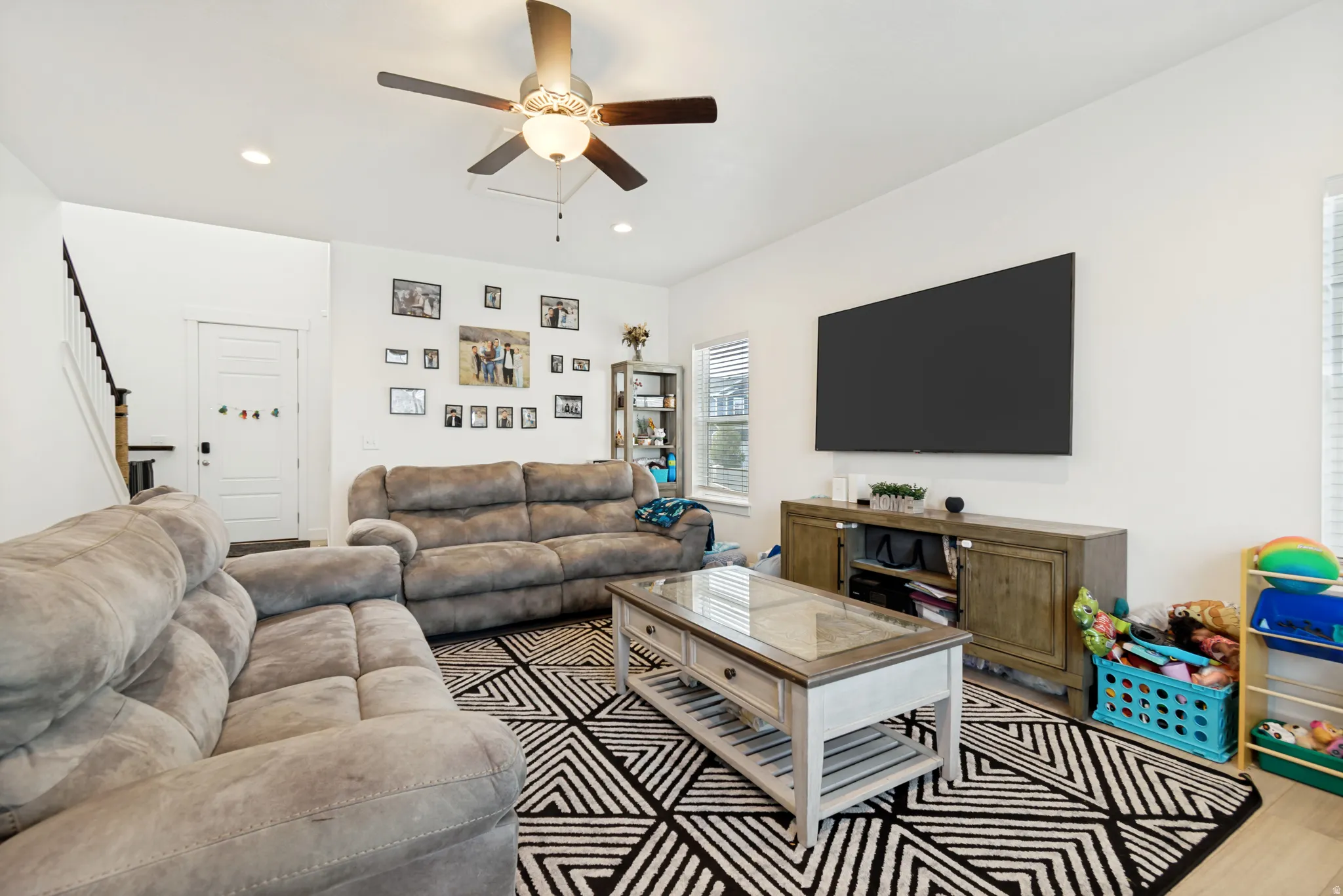Open-concept living space featuring light wood-finish flooring, recessed lighting, and a ceiling fan