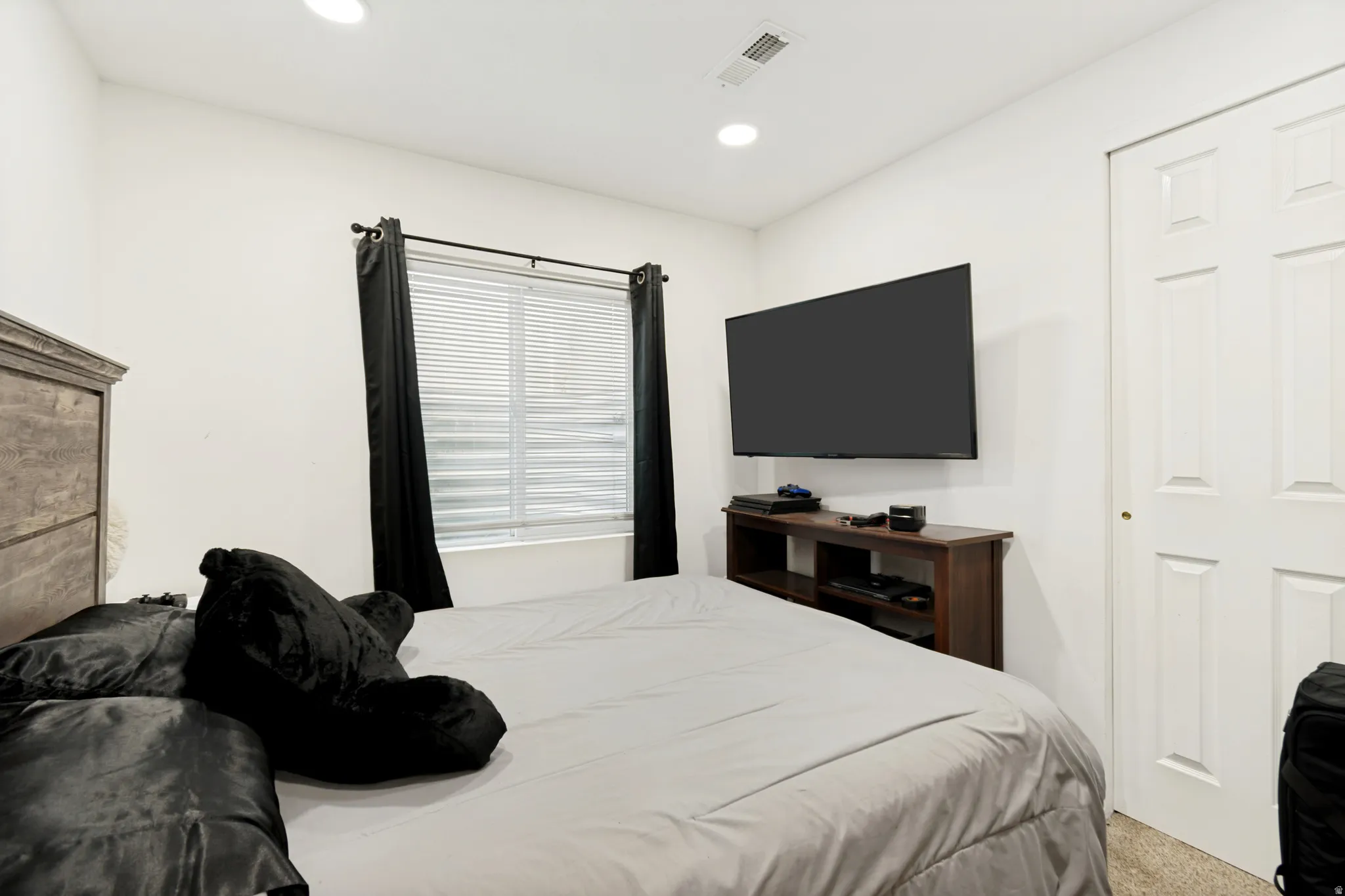 Room featuring a window with horizontal blinds, overhead recessed lighting, and a paneled closet door