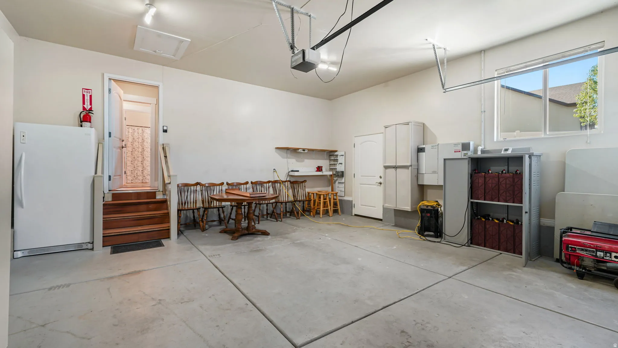 Spacious garage with concrete flooring, overhead lighting, and an exterior window