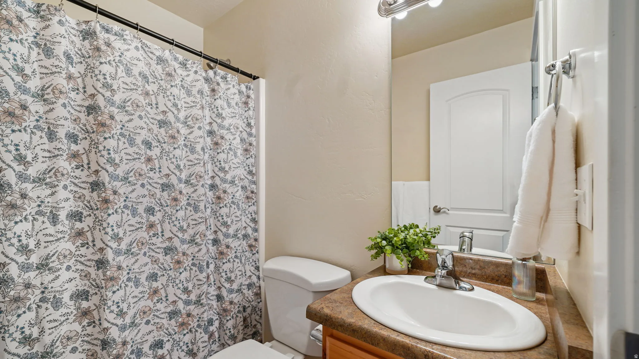 Bathroom featuring a vanity with an integrated sink, a brown countertop, and chrome fixtures