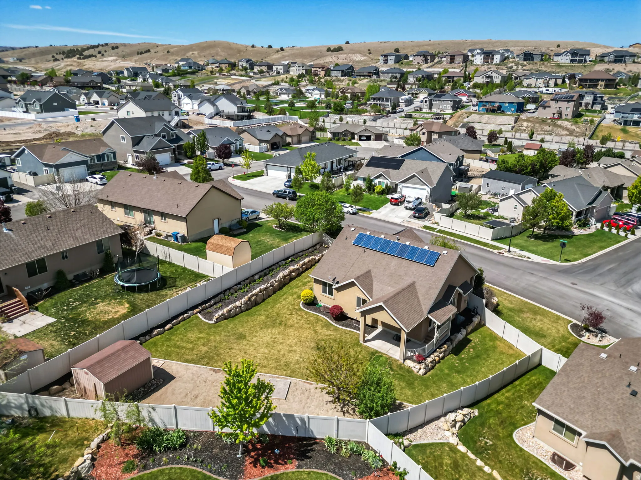 Contemporary residential property featuring an earth-toned exterior, a brown shingled roof, and rooftop solar panels