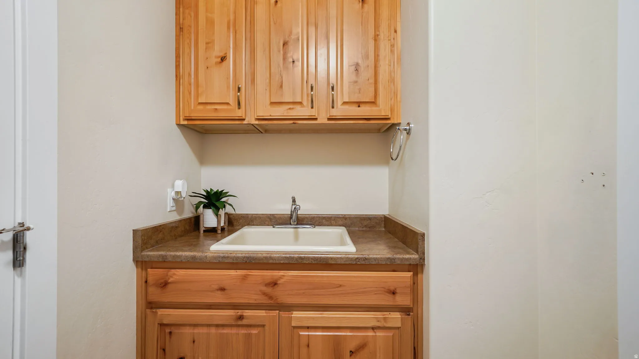 Utility sink with chrome faucet set into a laminate countertop