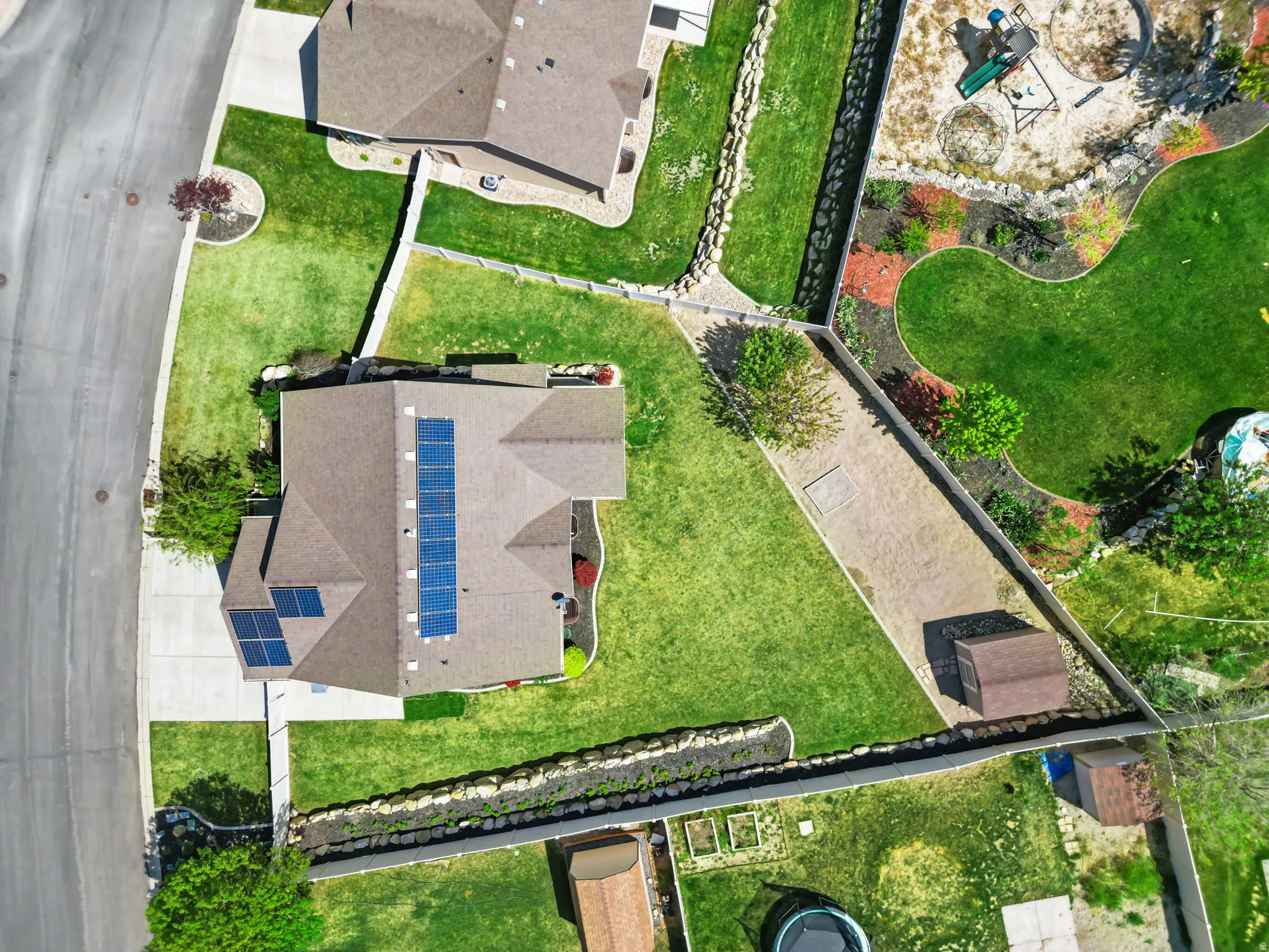 Property with solar panel array, expansive green lawn, and dedicated storage shed