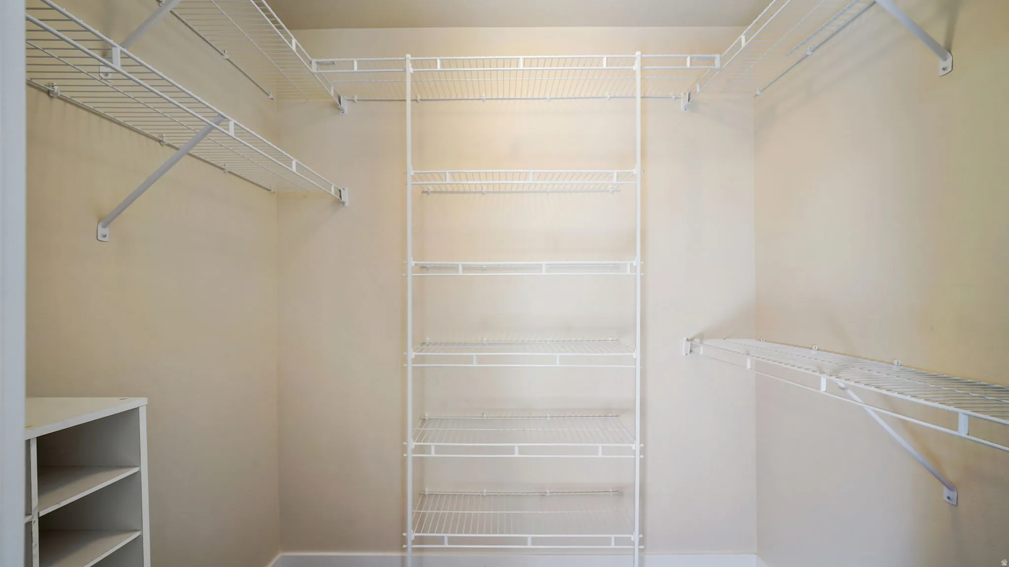 Walk-in closet featuring extensive white wire shelving and hanging rods