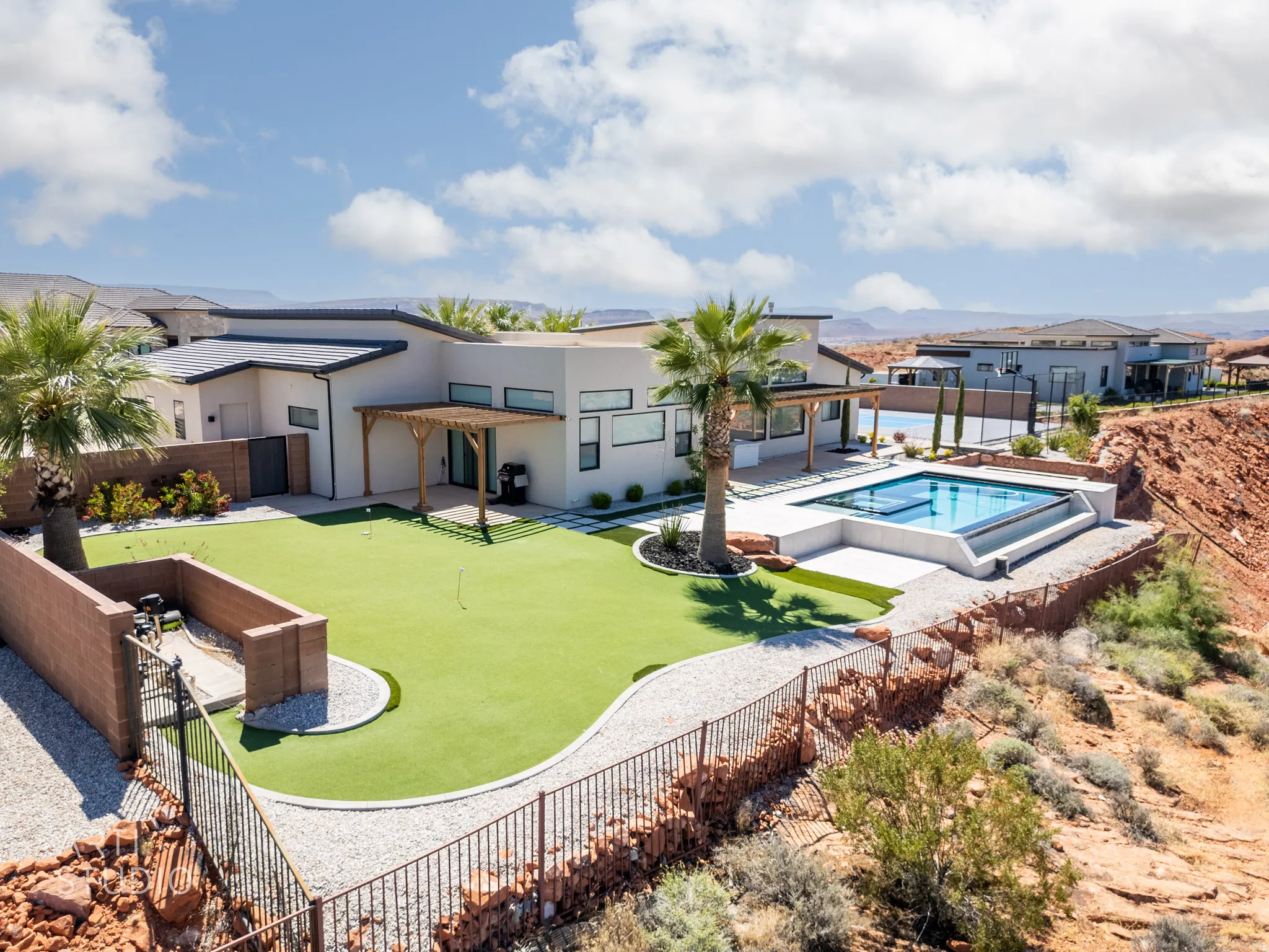 Contemporary home featuring a modern pool, integrated spa, expansive artificial turf area, and a pergola-covered patio