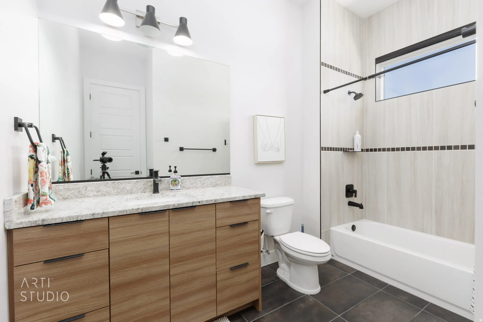 Contemporary bathroom featuring a light wood-finish vanity with a light-toned stone countertop