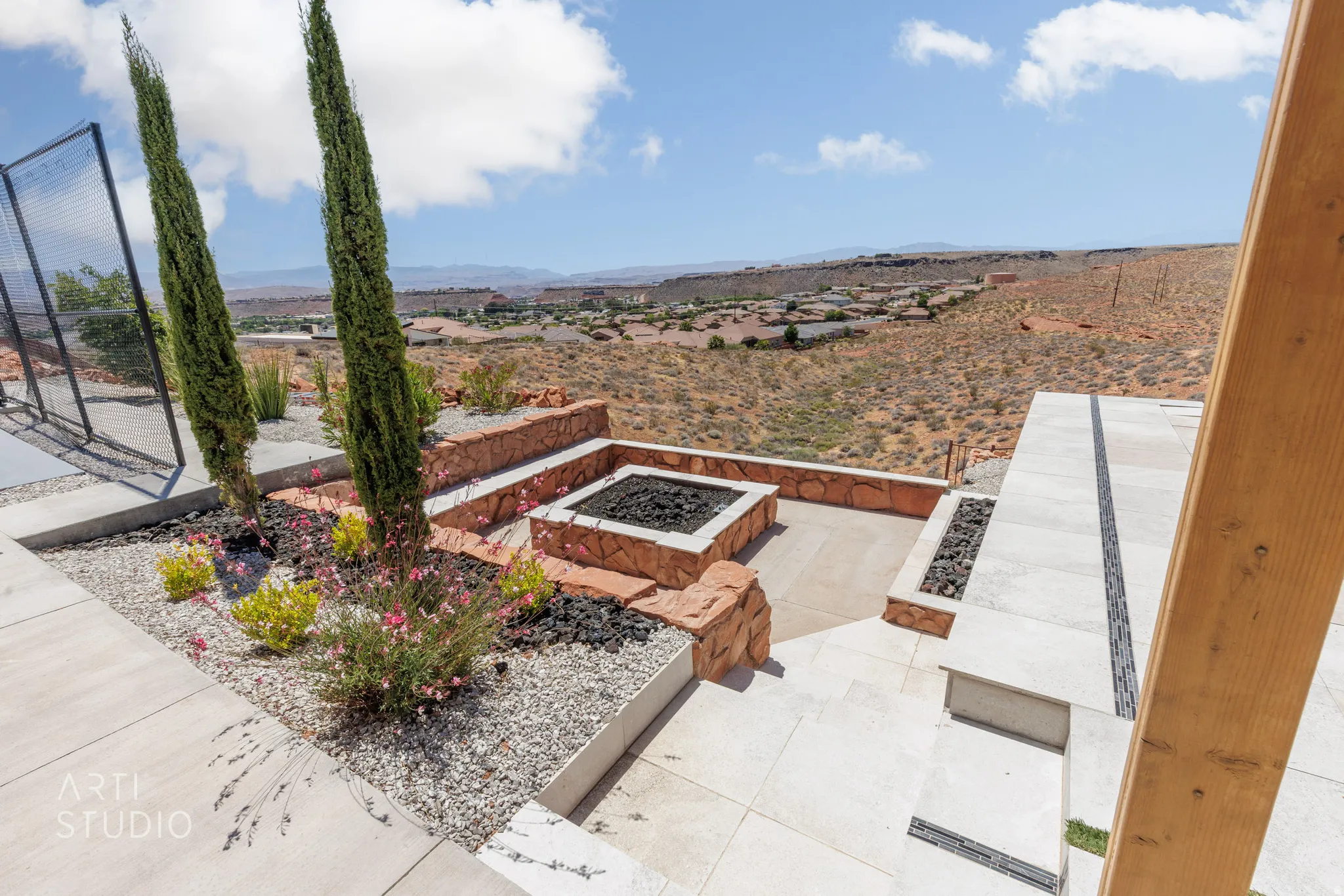 Outdoor living area featuring a built-in fire pit with stone surround, concrete patio, and integrated planters with cypress trees