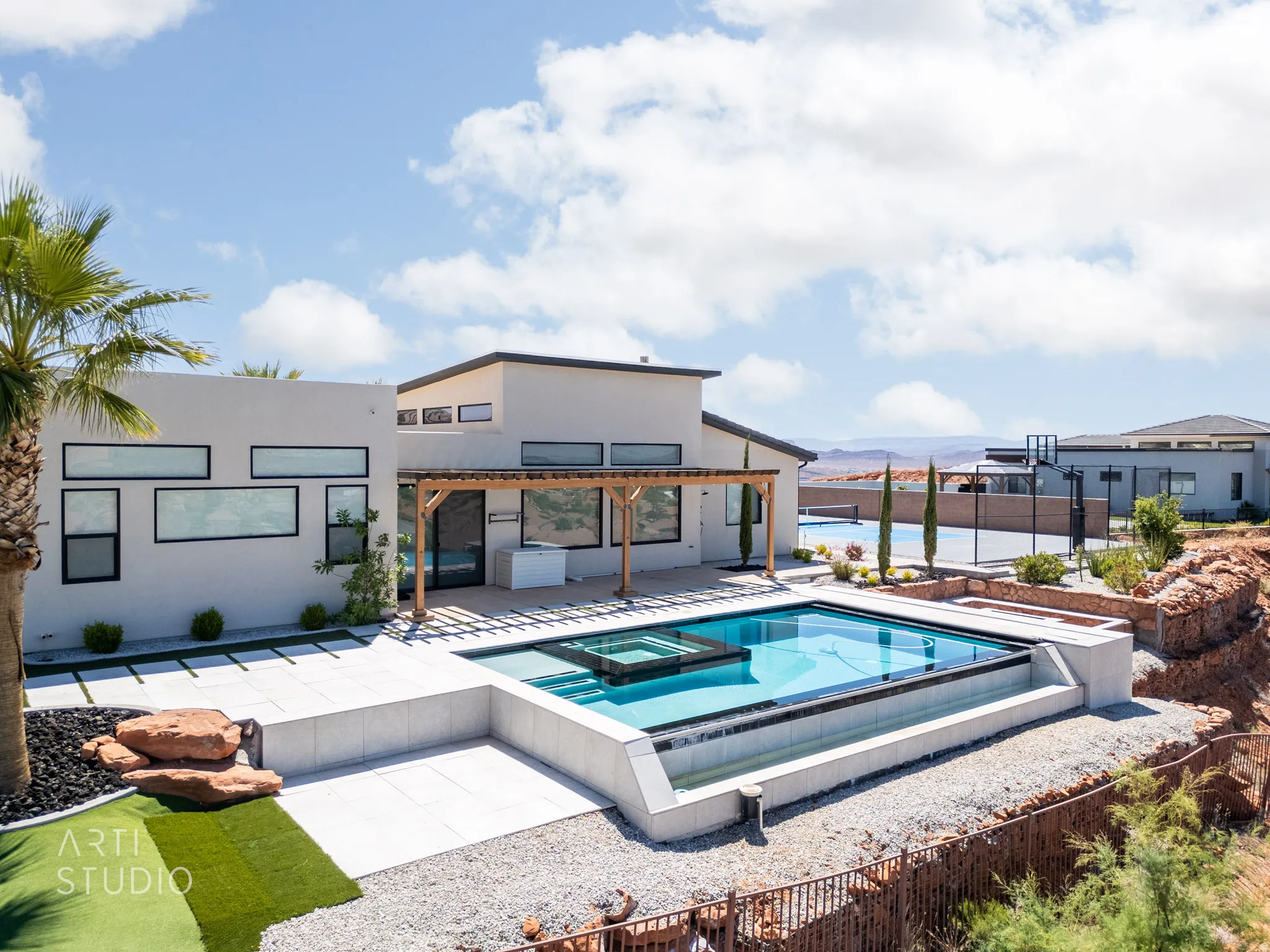 Modern exterior featuring a rectangular pool with an integrated spa, a wood pergola, and white exterior finishes