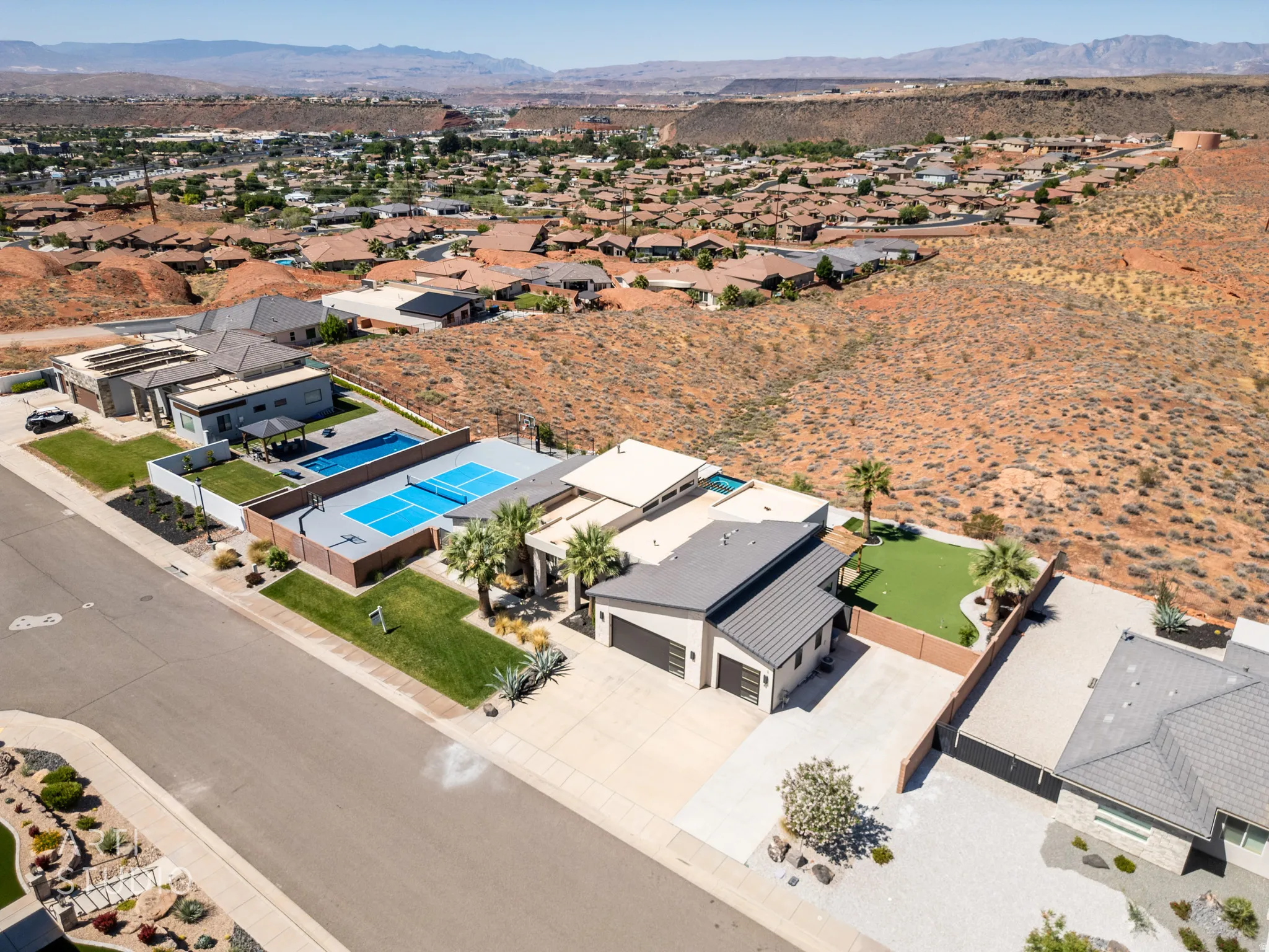 Modern desert landscape property with integrated sport court, swimming pool, and putting green