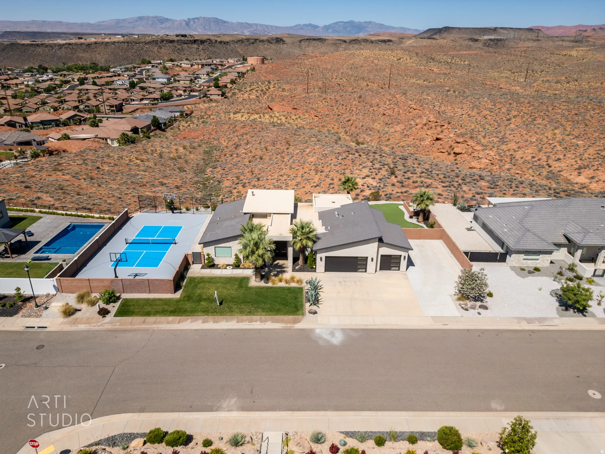 Modern residential property featuring a dedicated sports court, an inground swimming pool, and an artificial turf lawn