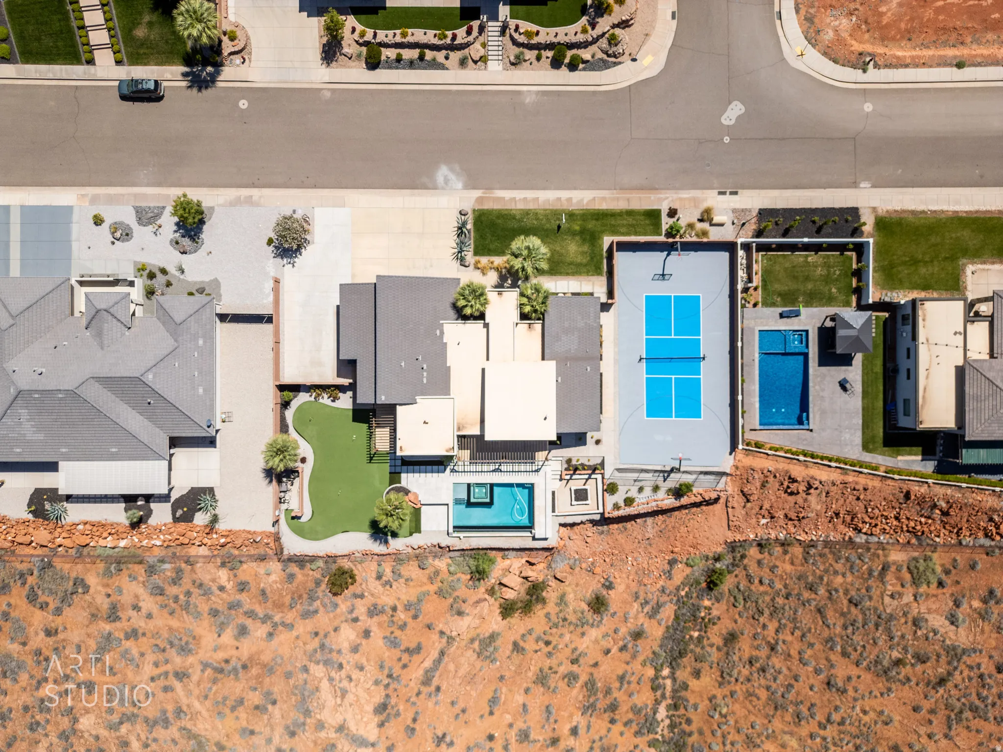Aerial view showcasing a modern property with a private pool, an artificial turf area, and a basketball court