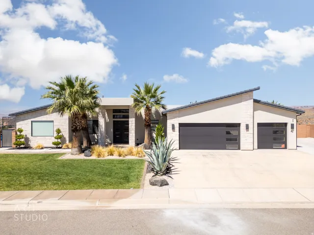 Contemporary single-story residence featuring a stucco and stone veneer facade with a sloped roofline