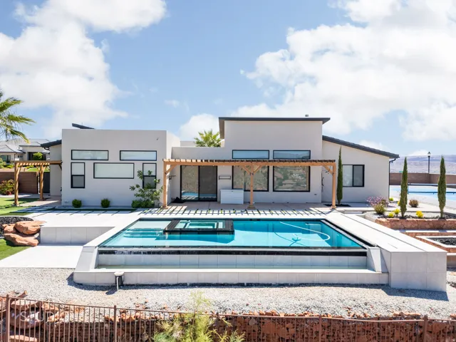 Modern exterior featuring a swimming pool with an integrated cover, extensive patio space, and a wooden pergola structure
