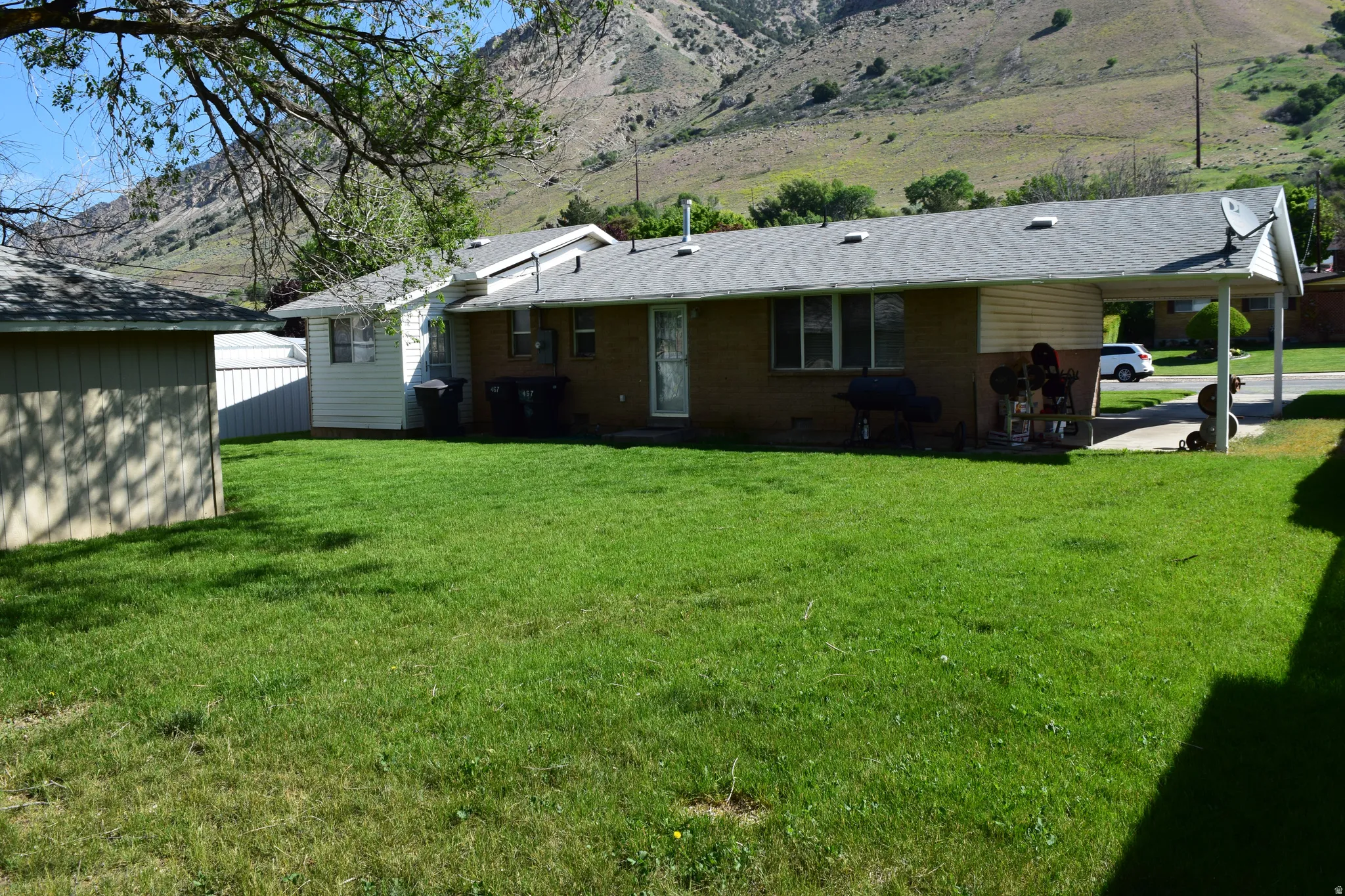 Expansive green lawn with a backdrop of rugged hills