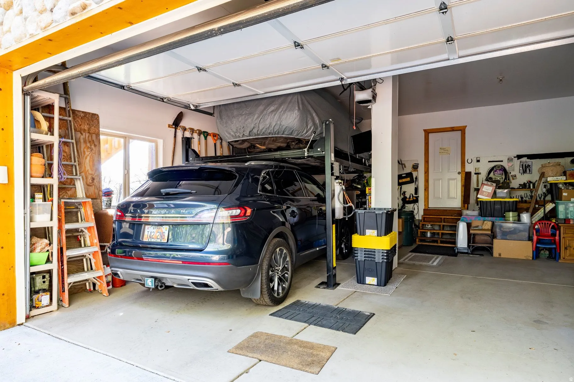 Spacious garage featuring a concrete floor, overhead door, and an interior access door with wood trim